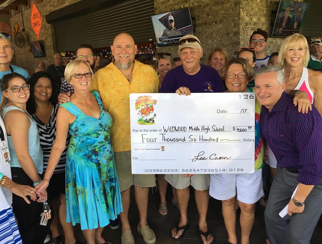 Wildwood Middle High School Principal Richard Hampton and more than 20 teachers present at the event receive a check from The Villages Parrot Heads.