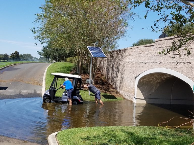 Hurricane Irma Damage - Rick Medina helps push a fellow Villagers cart out of flooded tunnel