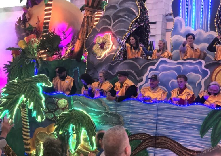 Villagers don costumes and toss beads at Universal Studios Mardi Gras Parade