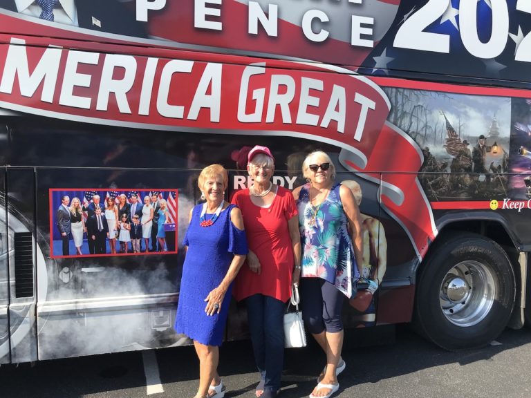 Gloria Stahr Kathy McLean and Cathy Slattery from left pose in front of the Trump Train bus.