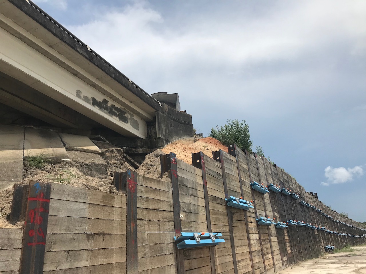 A truck dumps gravel from on high to fill the hole at the base of the U.S. Hwy. 27441 bridge over County Road 25.