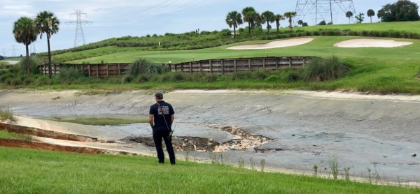 A firefighter with The Villages Public Safety Department looks out at the sinkholes which opened up this weekend behind the Moyer Recreation Center