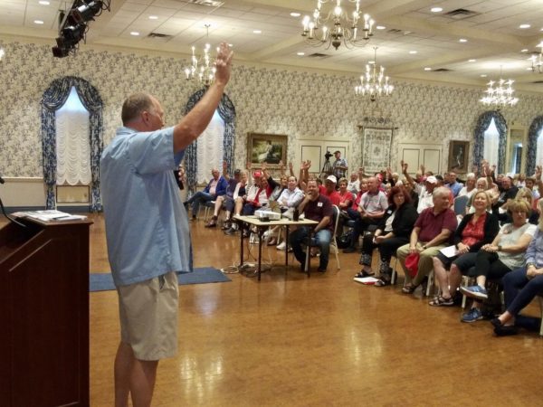 Villager Wayne Anderson asks for a show of hands while speaking to Villagers for Trump