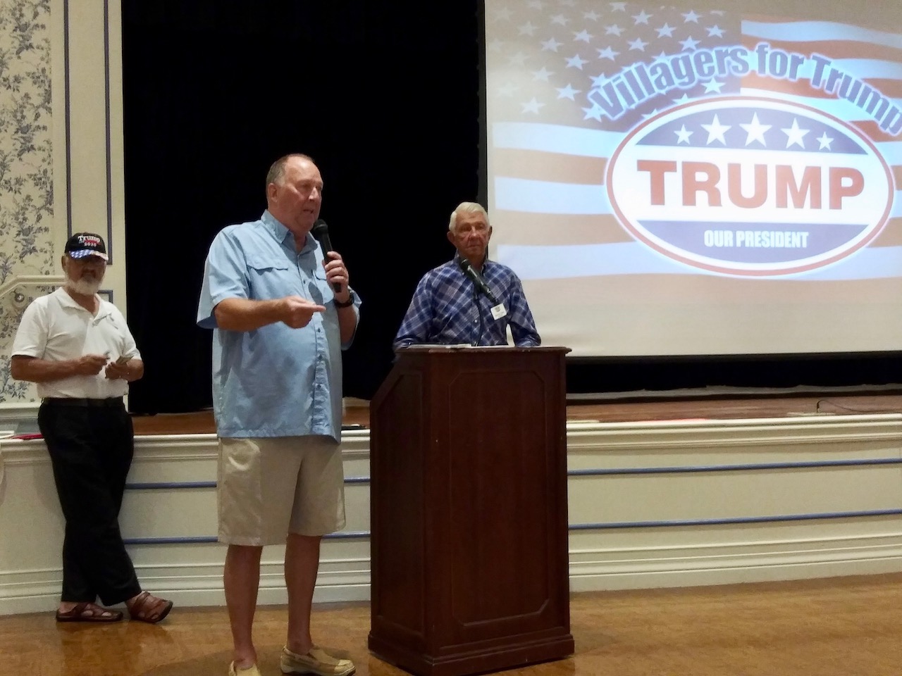 Villager Wayne Anderson at centter with microphone speaks to Villagers for Trump