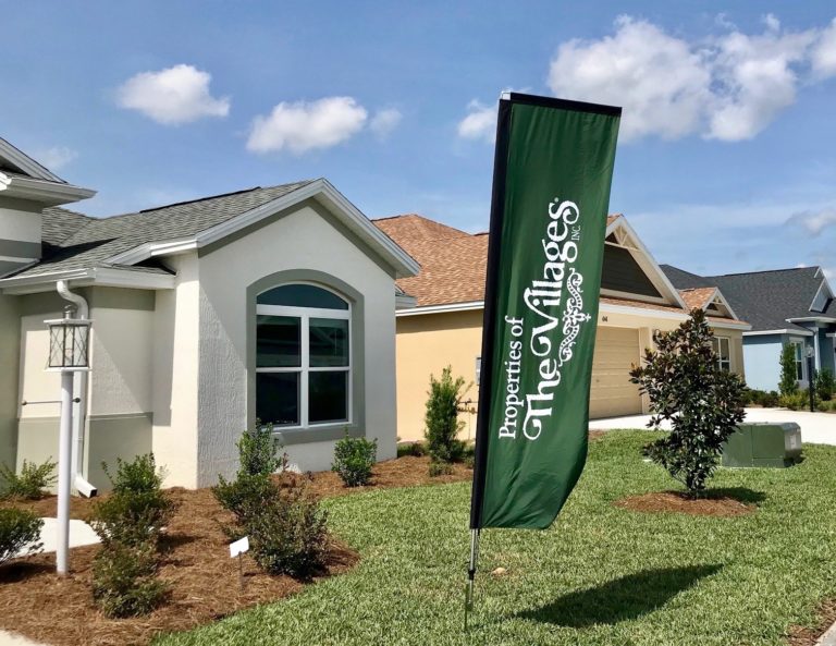 A Properties of The Villages flag is on display at a home in The Villages