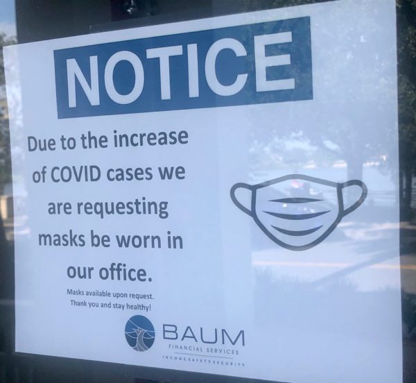 A sign at Baum FInancial Services advises customers they will need to wear a mask at the office at Lake Sumter Landing