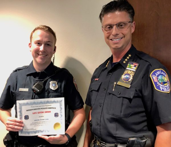 Officer Jacob Clark left was honored Monday night by Chief Robert Tempesta for saving a mans life at town square in The Villages
