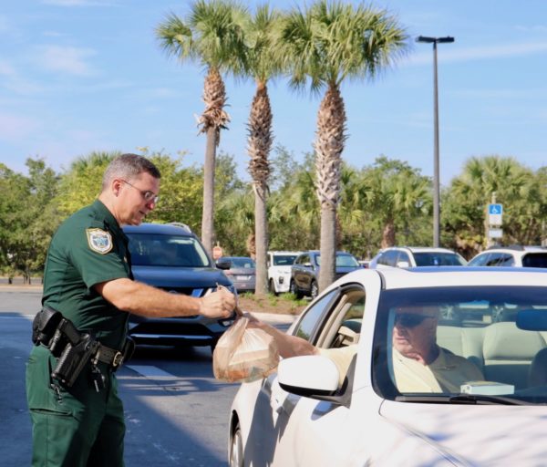 Lt. Robert Siemer collects a bag of medications for disposal at Winn Dixie.