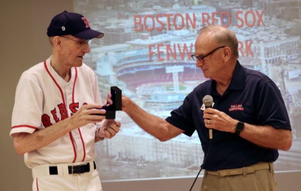 Villages Red Sox Nation President Dave Bedard presents the personalized ring of the founder of the Art Plant club who proudly wears his team uniform.