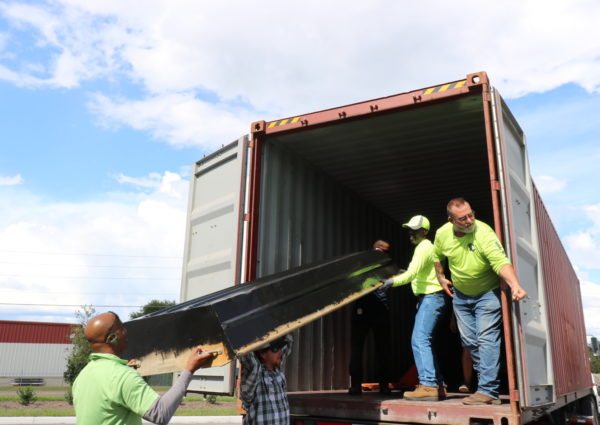 Volunteers load a boat onto the container headed to Haiti.