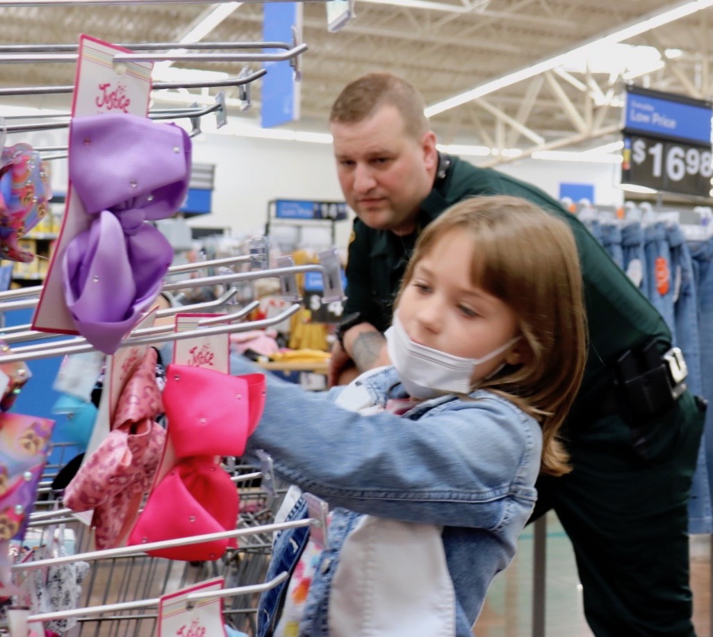 Detective Brian Zinn watches as 8 year old Kensley selects a ribbon