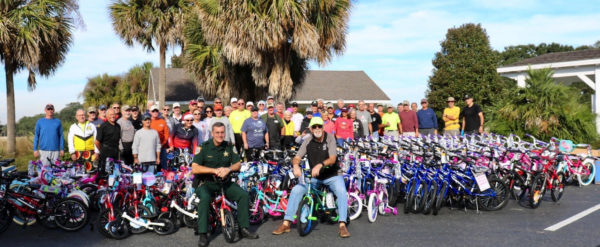 Lt. Robert Siemer and Dave Lawrence of the Sumter Landing Bicycle Club on bicycles with the many volunteers at the event Friday at Lake Miona Recreation Center.