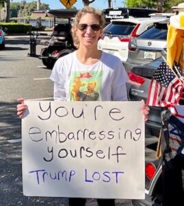 This protester was stationed at Lake Sumter Landing Market Square during the golf cart rally