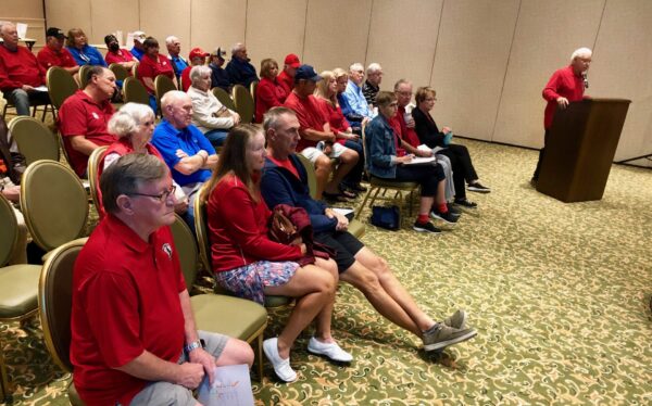 Villager Jim Vaccaro at podium with a large group of residents wearing red raised concerns about golf cart safety on Morse Boulevard Villager Jim Vaccaro at podium with a large group of residents wearing red raised concerns about golf cart safety on Morse Boulevard