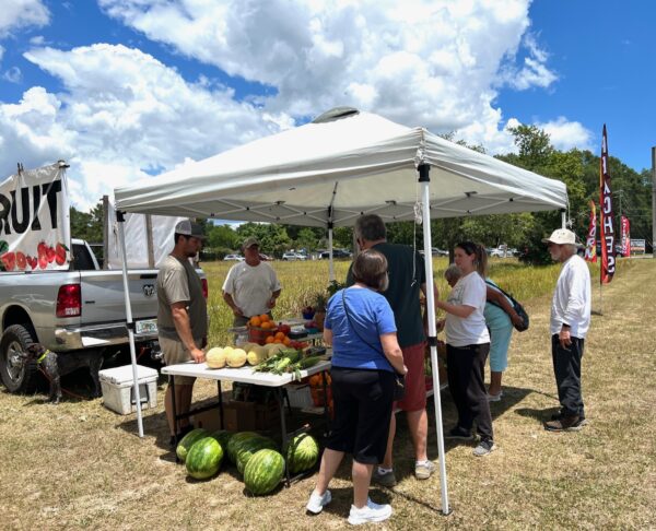 Customers lined up Friday afternoon for peaches sweet corn watermelon and other assorted fruits and vegetables.