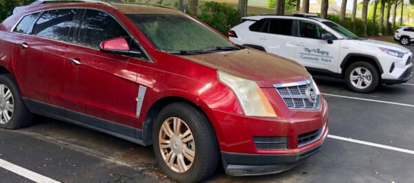 This apparently abandond Cadillac was photographed Sunday alongside a Community Watch vehicle at Savannah Center