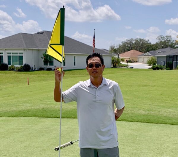 Brian Hirakami shows off his golf ball after his first hole in one