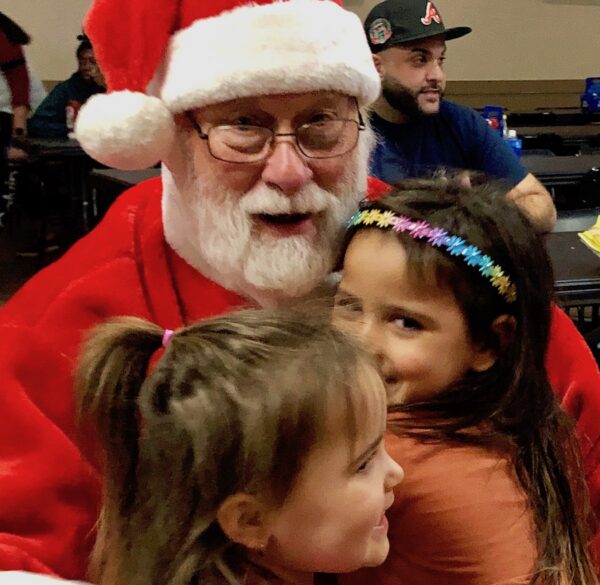 Appreciative children hugged Santa after receiving their new bicycles