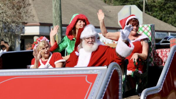 Santa and Mrs. Clause waived to the spectators as they rode in a grand sleigh. Santa and Mrs. Clause waived to the spectators as they rode in a grand sleigh.