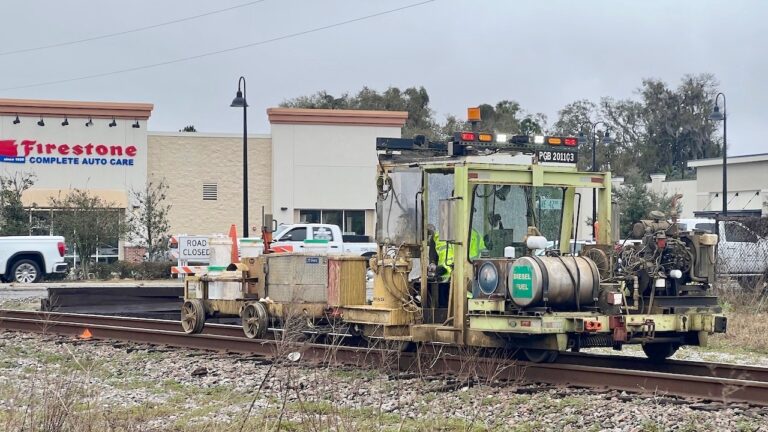 A railroad work was marking ties just south of railroad crossing at County Road 466