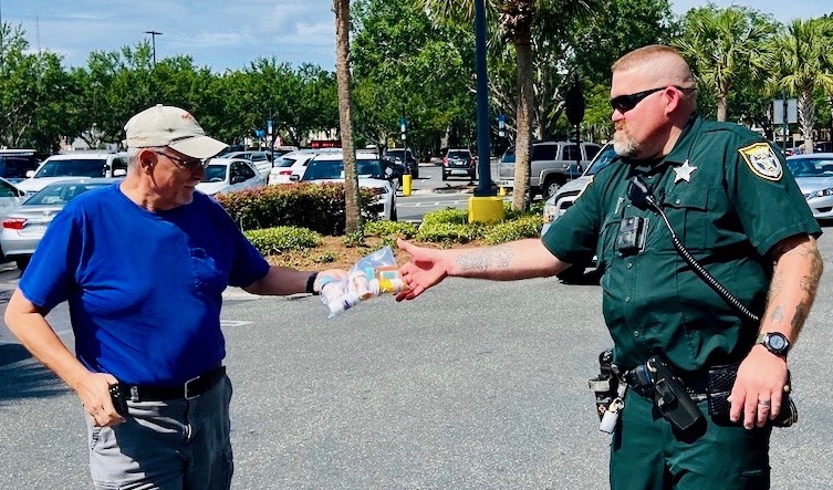 Villager Bill Westwood drops off a bag of prescription drugs to Deputy Henshaw during the drug collection day.