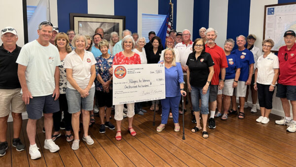 Nadine Landis, holding check at left, donates $1,500 to Marie Bogdonoff, with check at right, of Villagers for Veterans