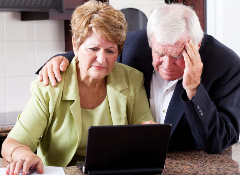 unhappy senior couple worrying about expenses