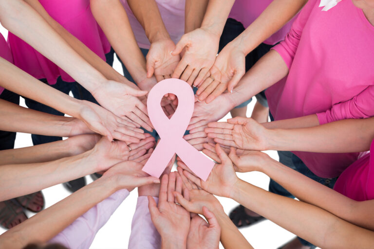 Hands joined in circle holding breast cancer struggle symbol on white background