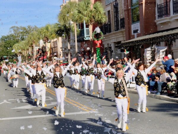 The Villages Twirlers & Drum Corps marched down Main Street in the Christmas Parade, bringing artificial snow with them