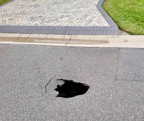 Nervous neighbors keep watchful eye after hole opens up on their street ...