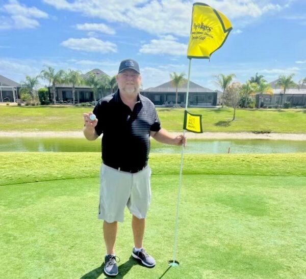 Steven McCurry shows off his golf ball after getting a hole in one