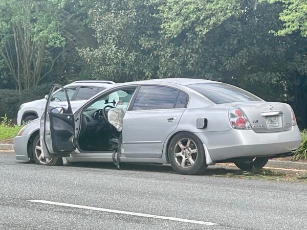 The airbag deployed in this silver Nissan as a result of the crash