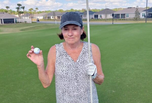 Bonnie Ennis shows off her golf ball after scoring the lucky