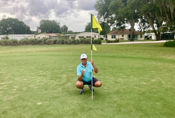 Matthew Benedict shows off his golf ball after getting the lucky ace
