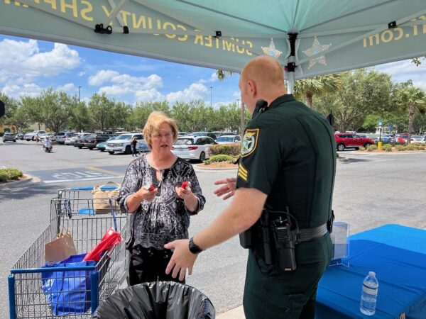 Sgt. Adam Dodge of the Sumter County Sheriffs office helps Sherry Evans of Bushnell dispose of medications