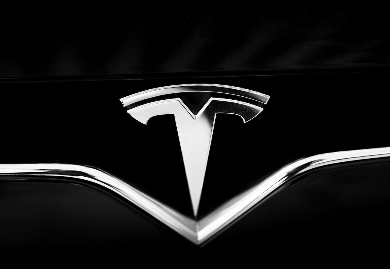 Tesla Emblem on Black Car. Close Up Silver Logo