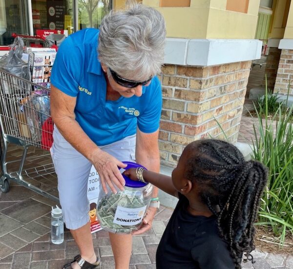 Martha Friedman, Village of Ashland, accepts donations from a young shopper at Winn Dixie Pinellas Plaza.
