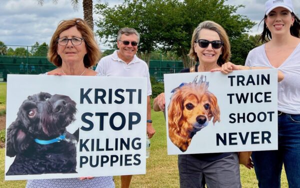 Rochelle Larson, left, and Theresa Perez held up signs in protest of Gov. Krisit Noem's visit to The Villages