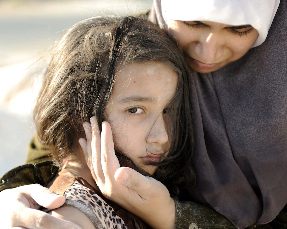 Poverty and poorness on the children face. Sad little girl. Refugee. In Muslim mother 039;s arms.