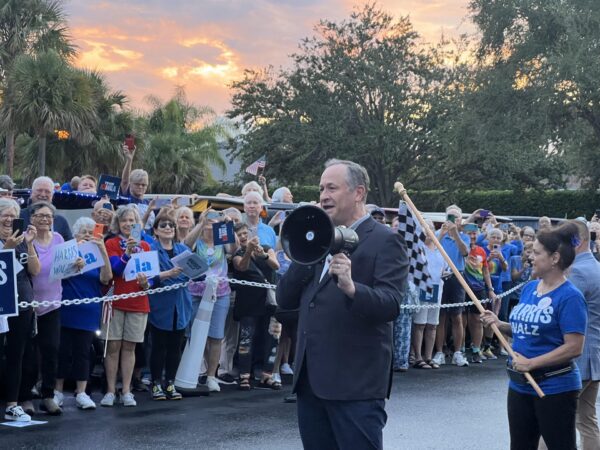 Doug Emhoff, with bullhorn, spoke to Villagers in the parking lot of Lake Miona Recreation Center, prior to a golf cart rally Doug Emhoff, with bullhorn, spoke to Villagers in the parking lot of Lake Miona Recreation Center, prior to a golf cart rally