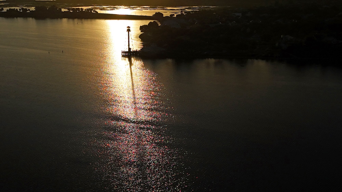 Lighthouse reflecting off the waters of Lake Sumter at sunrise