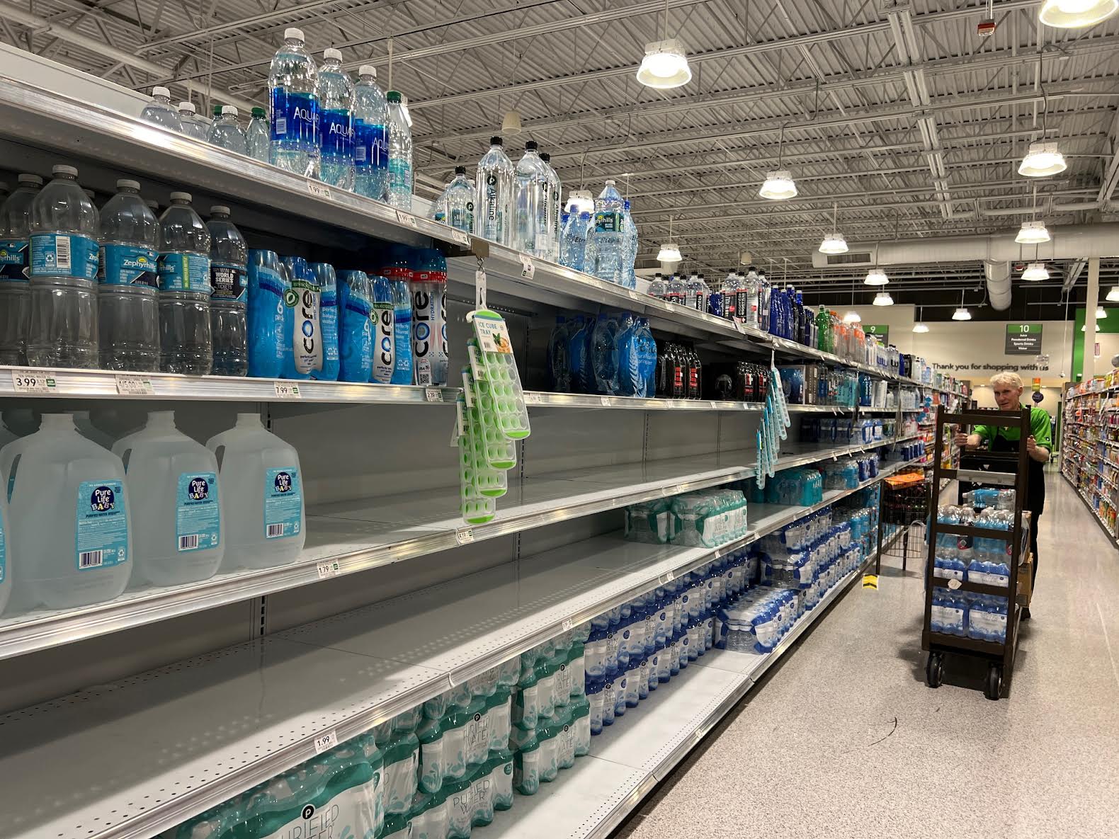 A clerk was busy restocking shelves with bottled water Sunday at Publix at Colony Plaza in The Villages
