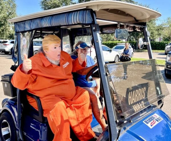 A participant in a Donald Trump costume, complete with orange jumpsuit, joined in the golf cart parade A participant in a Donald Trump costume, complete with orange jumpsuit, joined in the golf cart parade