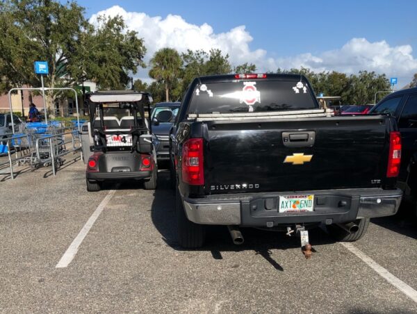This pickup and a golf cart were crowded in near the shopping carts at Walmart at Buffalo Ridge Plaza This pickup and a golf cart were crowded in near the shopping carts at Walmart at Buffalo Ridge Plaza