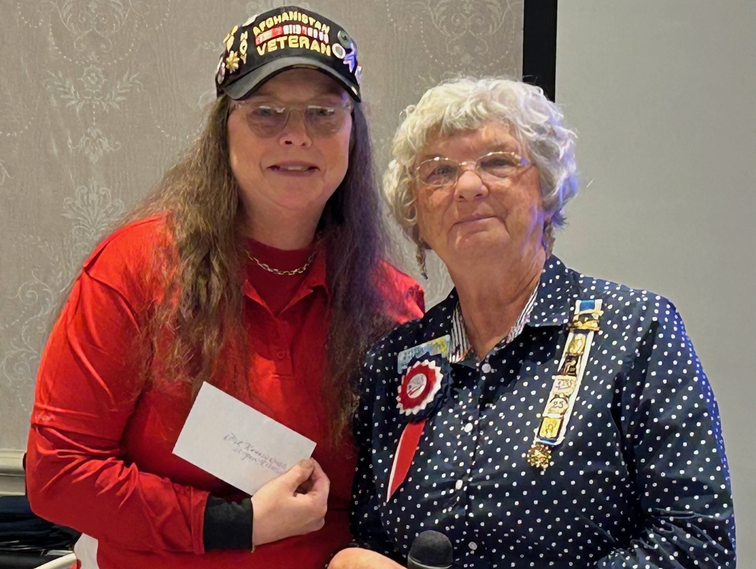 LCDR Kathryn Wilgus, NC Navy Retired, left, holds an honorarium presented by Sylvia Walden, Puc Puggy Chapter Regent.