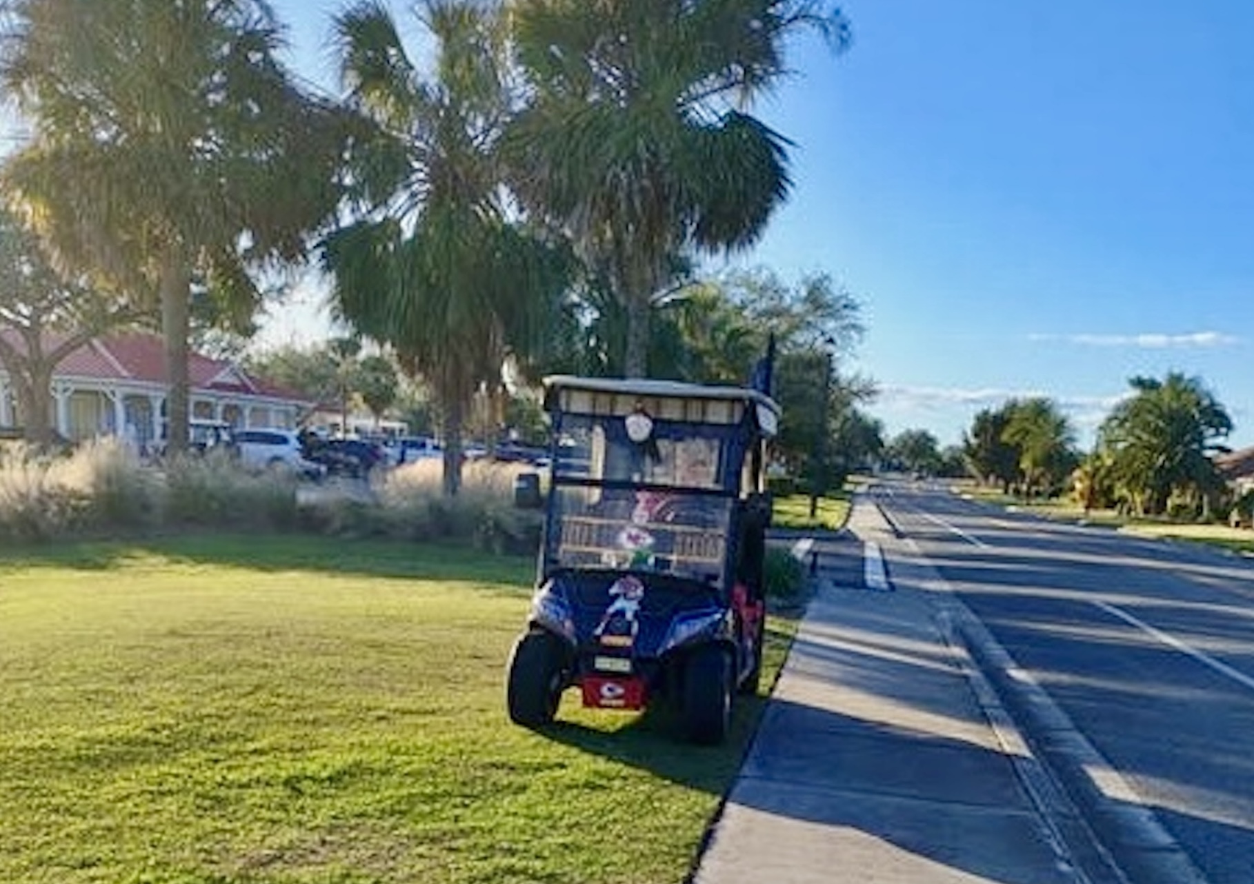 This golf cart, with Kansas City Chiefs insignia, was parked on the grass for some reason.