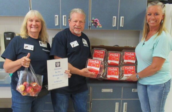 Sharon and Corey Gold, from left, hand off apples to Michelle Yoder in Fruitland Park for distribution to local teachers Sharon and Corey Gold, from left, hand off apples to Michelle Yoder in Fruitland Park for distribution to local teachers
