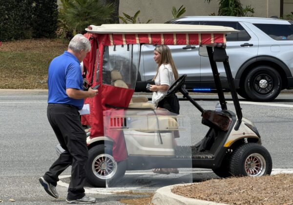 A police investigator approaches the gofl cart that was struck in the accident A police investigator approaches the gofl cart that was struck in the accident