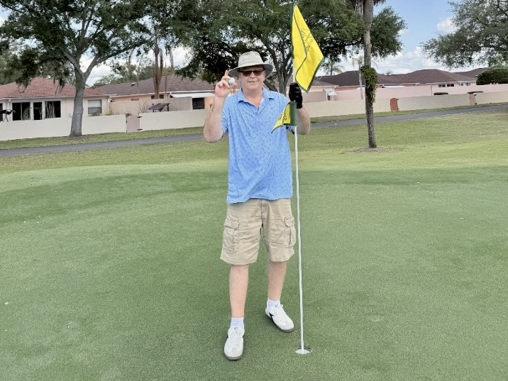 Dan Hinman proudly shows off his ball after scoring the lucky ace