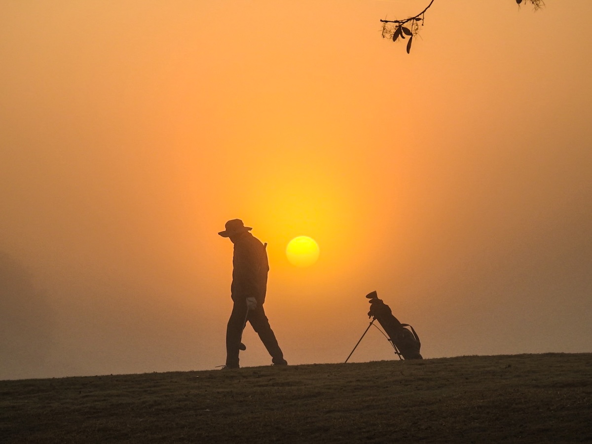 Golfer greets sunrise at Briarwood Executive Golf Course Golfer greets sunrise at Briarwood Executive Golf Course
